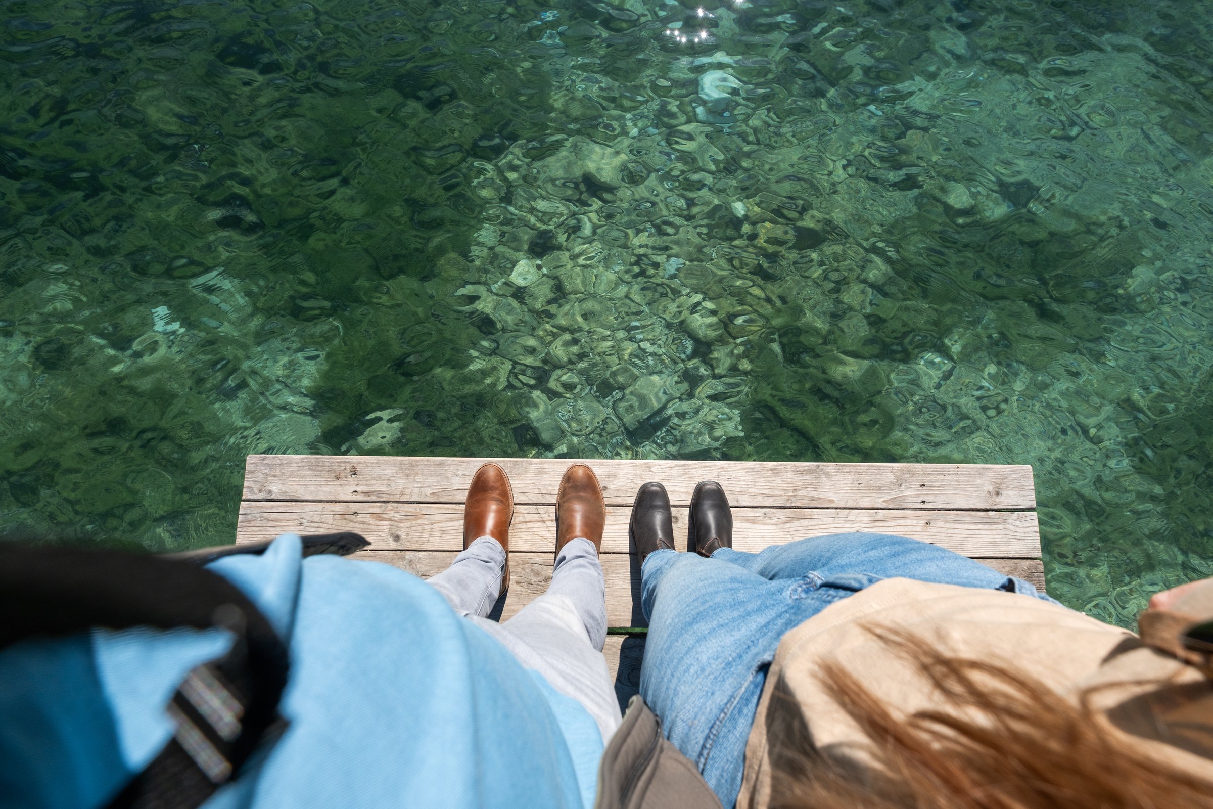 Feet over emerald water